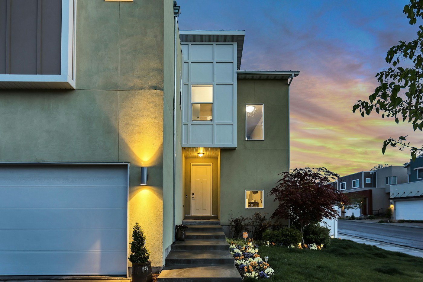 Front door of a home at dusk with the porch light on